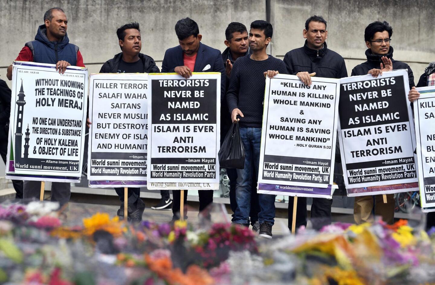 Gathering south of London Bridge, menhold placards denouncing the attackers as not following Islam.