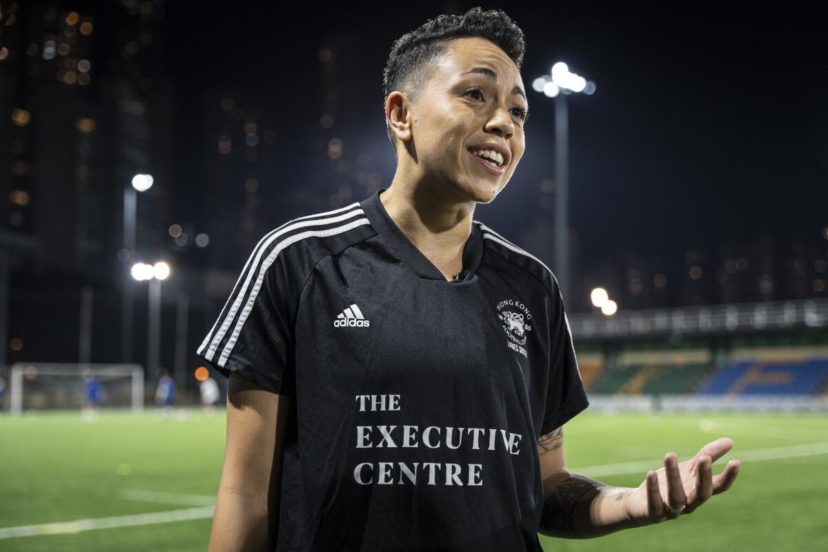 Gina Benjamin stands in front of a soccer field.