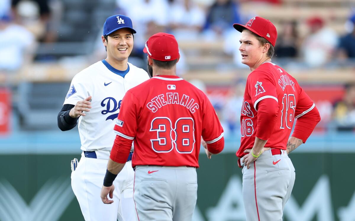 Dodgers star Shohei Ohtani, left, greets Angels infielders Michael Stefanic, center, and Mickey Moniak before Friday's game.