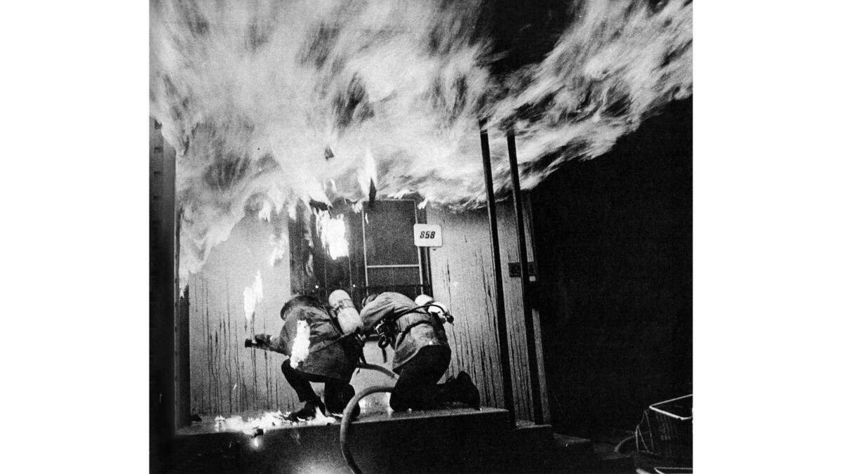 Feb. 2, 1973: Los Angeles County firemen duck as flames burst out of door at home on W. Knoll Drive in West Hollywood.