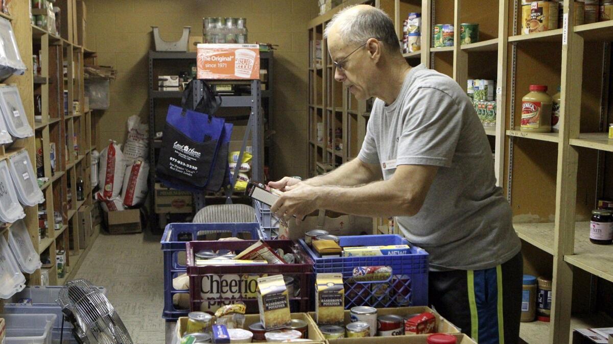Salvation Army volunteer Jerry Battinelli arranges donations in the pantry at the Salvation Army Family Store in Redding, Calif.