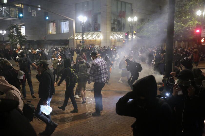 Police used tear gas and stun grenades on a group of protesters in downtown Portland on Tuesday night, June 2, 2020. Protests continued for a sixth night in Portland, demonstrating over the death of Minneapolis resident George Floyd. Floyd died after being restrained by Minneapolis police officers on May 25. (Brooke Herbert/The Oregonian via AP)