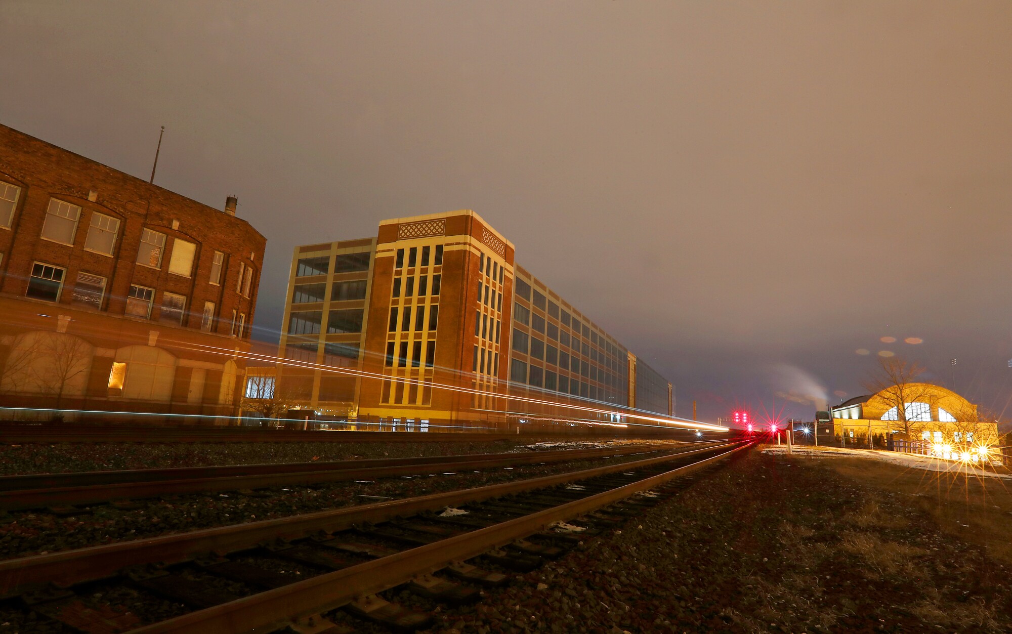 A freight train rolls through South Bend, Ind., between the former Studebaker automobile factory, left, and the old Union Station.