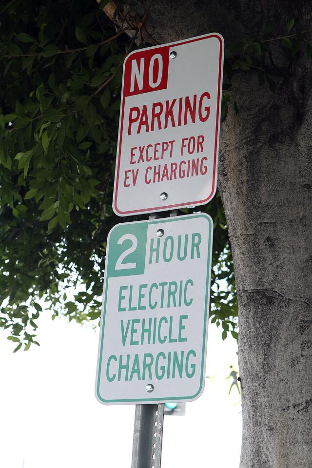 Parking signs on Hollywood Way for one of the eight dual-charger, electric-vehicle charging stations in Burbank are shown on Tuesday, Aug. 25, 2015.