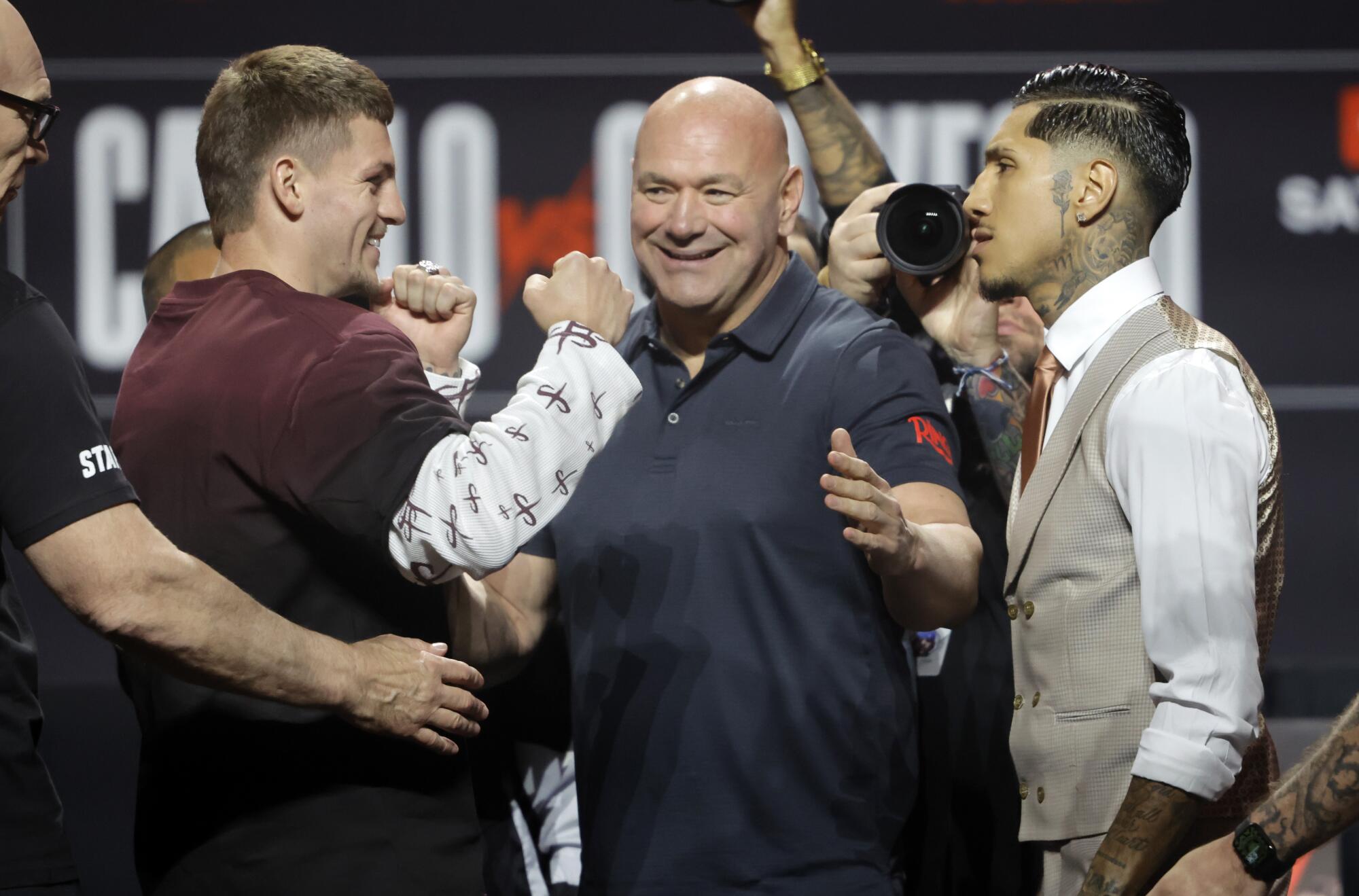 أغلقت عمود الملاكمين والش وفرناندو فيوسي جونيور خلال مؤتمر صحفي يوم الخميس بينما تبدو UFC Dana White بيضاء.