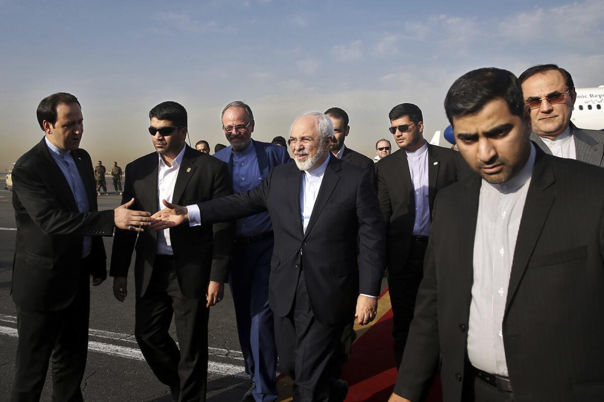 El canciller de Irán, Mohamed Javad Zarif, que es además el principal negociador nuclear iraní (en el centro), da la mano a un funcionario a su llegada al aeropuerto Mehrabad en Teherán, Irán, el 15 de julio de 2015. (Foto AP/Ebrahim Noroozi)