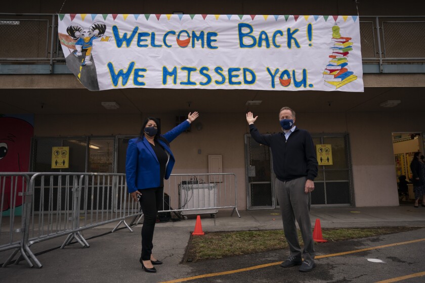 Los Angeles Unified School District Superintendent Austin Beutner, right, and Gabriela Rodriguez, principal of Heliotrope Avenue Elementary School, pose for photos on the first day of in-person learning in Maywood, Calif., Tuesday, April 13, 2021. More than a year after the pandemic forced all of California's schools to close classroom doors, some of the state's largest school districts are slowly beginning to reopen this week for in-person instruction. (AP Photo/Jae C. Hong)