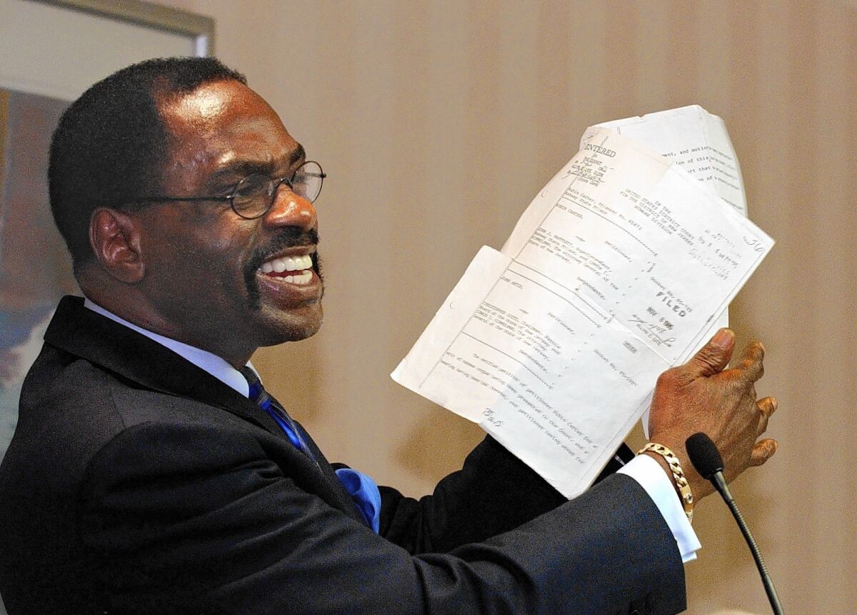 Former boxer Rubin "Hurricane" Carter holds up the writ of habeas corpus that freed him from prison, during a news conference held in Sacramento, Calif., in 2004. Carter, who spent almost 20 years in jail after twice being convicted of a triple murder he denied committing, has died at his home in Toronto at 76.
