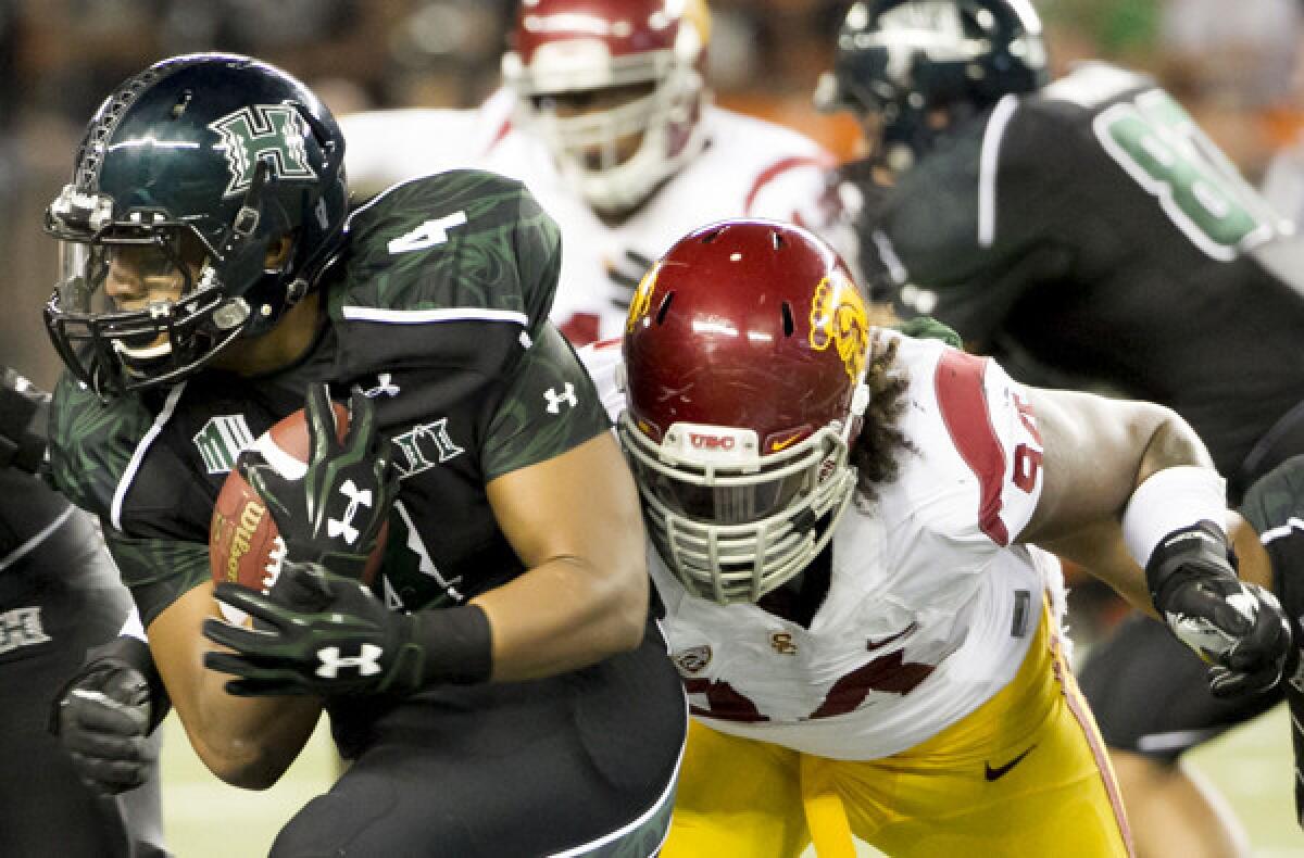 USC defensive end Leonard Williams brings down Hawaii running back Steven Lakalaka in the third quarter of their season-opening game on Thursday in Honolulu.