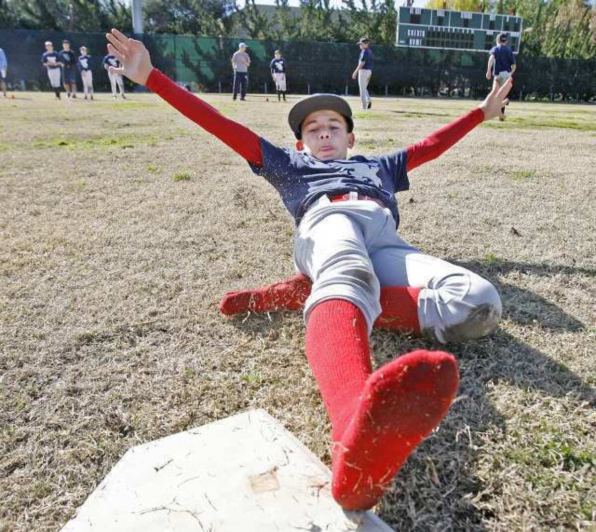 Alex Jilizian, 13, of Glendale, successfully slides into a base during a drill at the Annual Falcon Baseball Camp at Stengel Field in Glendale.