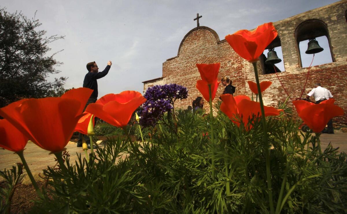 At Mission San Juan Capistrano, visitors photograph the historic bells during a celebration of St. Joseph's Day and the return of the swallows.