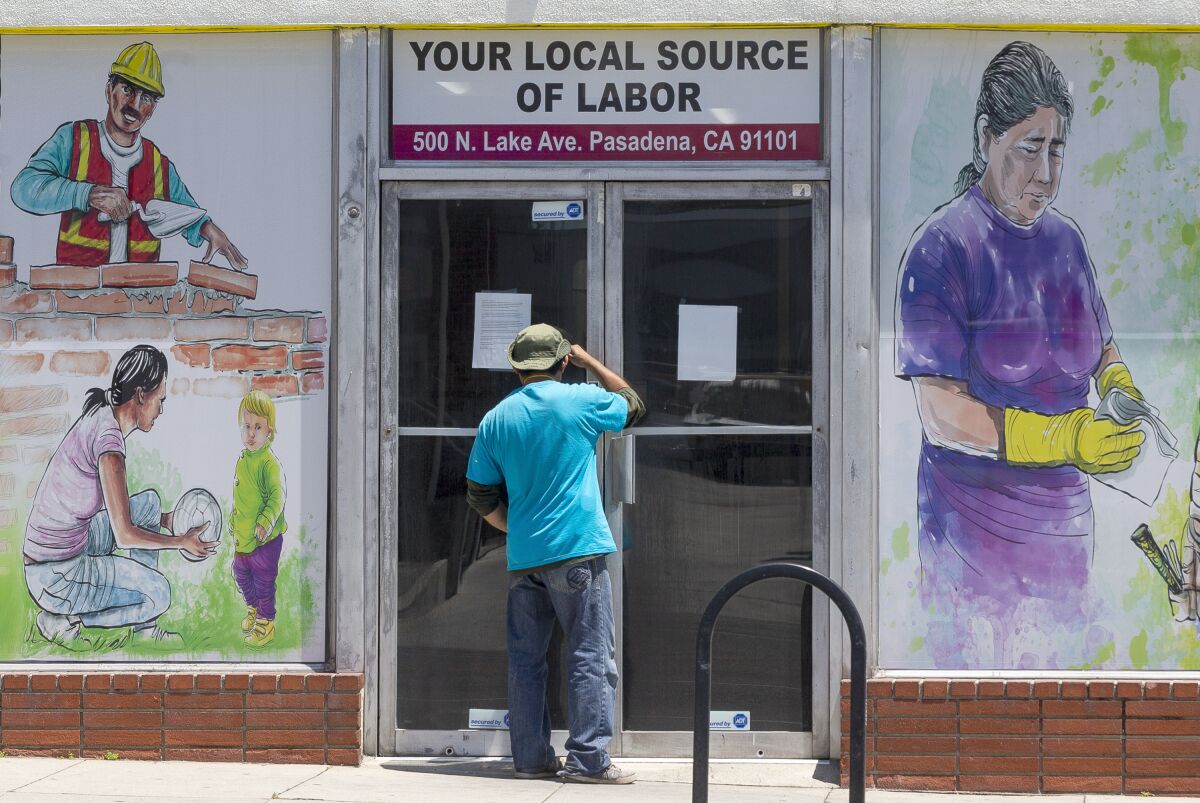 A worker looks inside the closed doors of the Pasadena Community Job Center on May 7