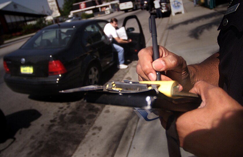 An LAPD officer writes a ticket to a driver who didn't stop for pedestrians on Reseda Boulevard in Northridge.