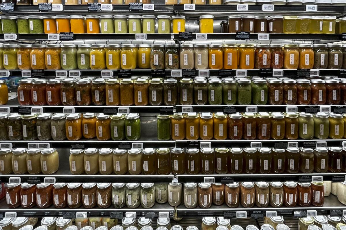 Eight shelves of Mason jars filled with soups at an Erewhon Market