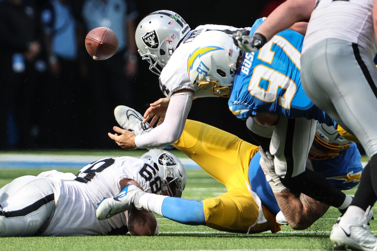 Raiders quarterback Derek Carr (4) fumbles as he is sacked by Chargers linebacker Joey Bosa (97) in their season opener.