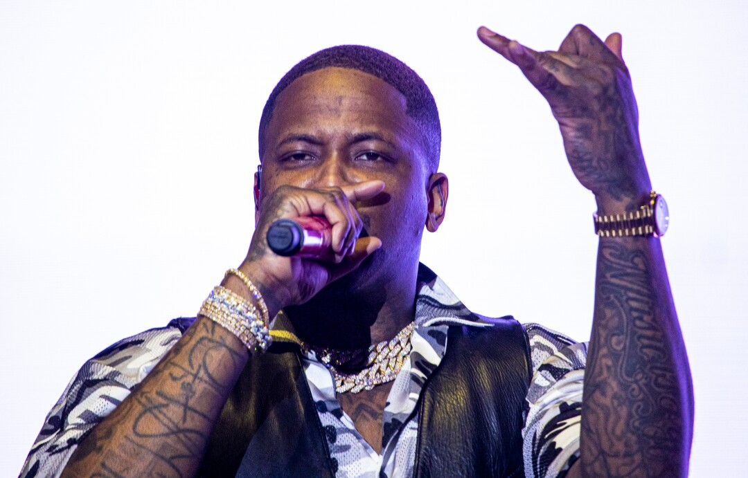 YG raises a tattooed arm while performing.