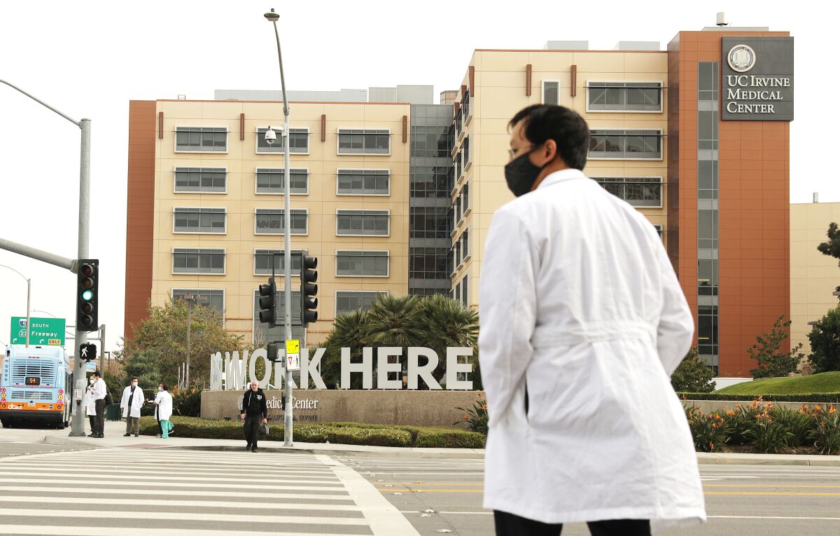 A healthcare worker walks outside UC Irvine Medical Center in Orange.