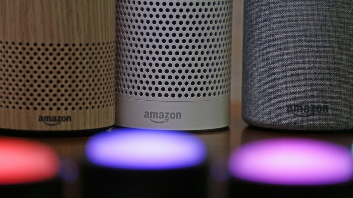 Amazon Echo and Echo Plus devices sit near illuminated Echo Button devices during a company event in Seattle.