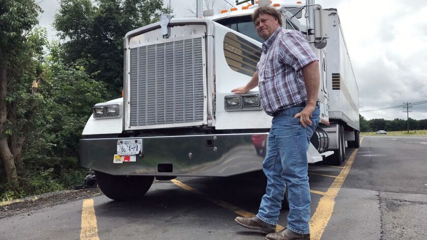 Terry Button, shown with his truck during a stop in Opal, Va., supports easing the rules. “How can you judge me and what I do by sitting in a cubicle in an office?” he said.