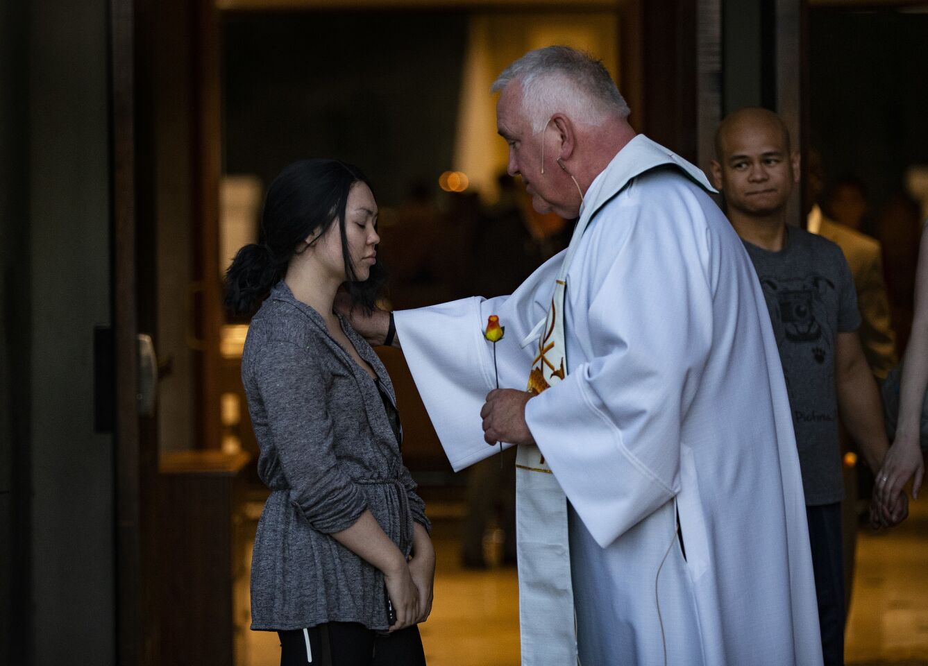 Father Bob Stoeckig prays with a resident after an interfaith event at Guardian Angel Cathedral to mark the first anniversary of the Las Vegas mass shooting.