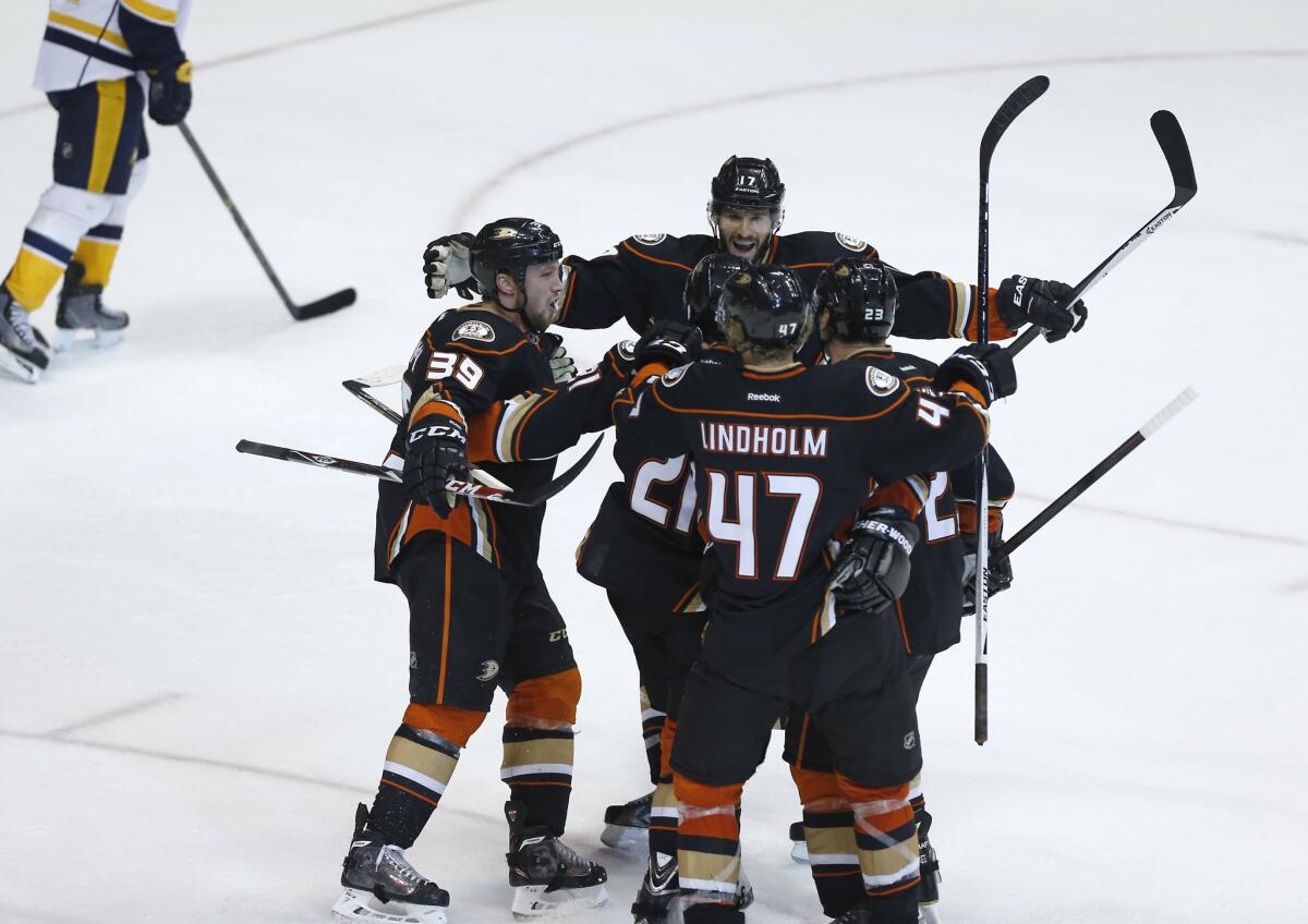 Kyle Palmieri is surrounded by his teammates after scoring a goal in the third period of the Ducks' 4-2 come-from-behind victory over the Nashville Predators.