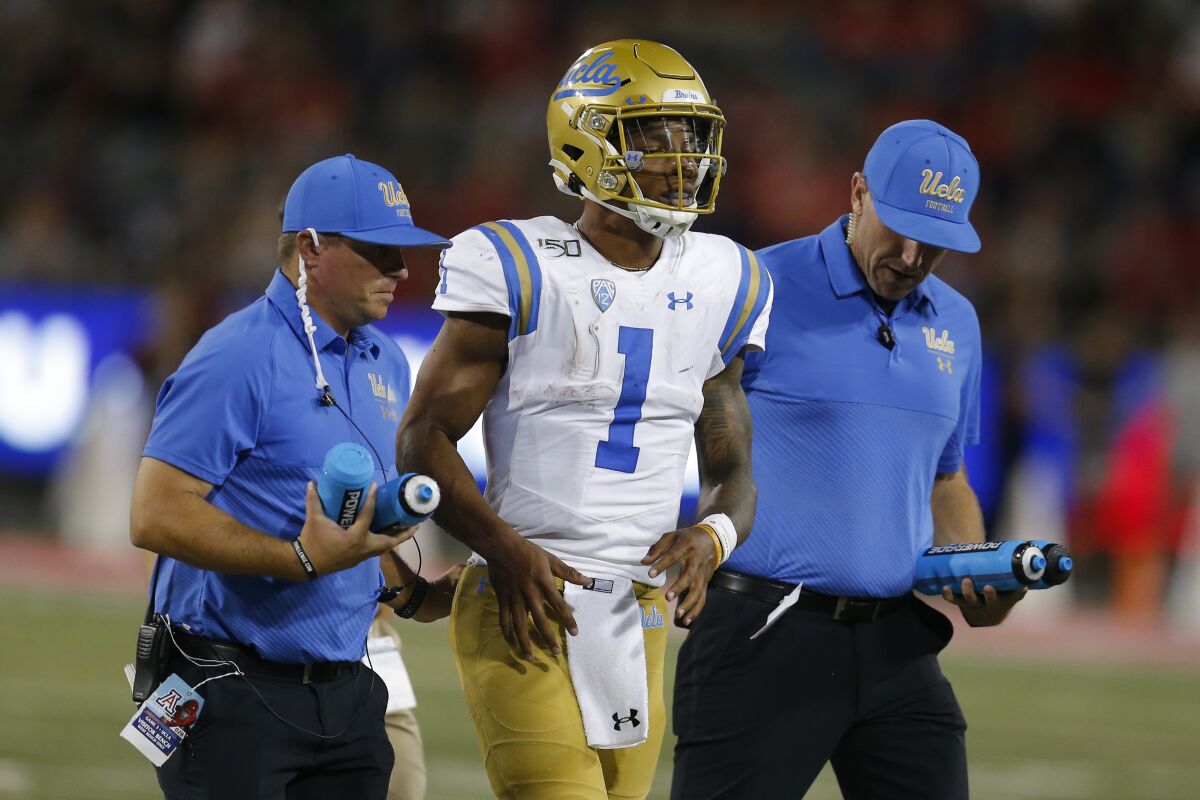UCLA quarterback Dorian Thompson-Robinson leaves the field after suffering an apparent ankle injury in the third quarter.