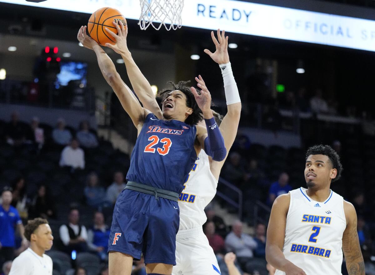 Cal State Fullerton guard Tory San Antonio is fouled by UC Santa Barbara guard Matija Belic.