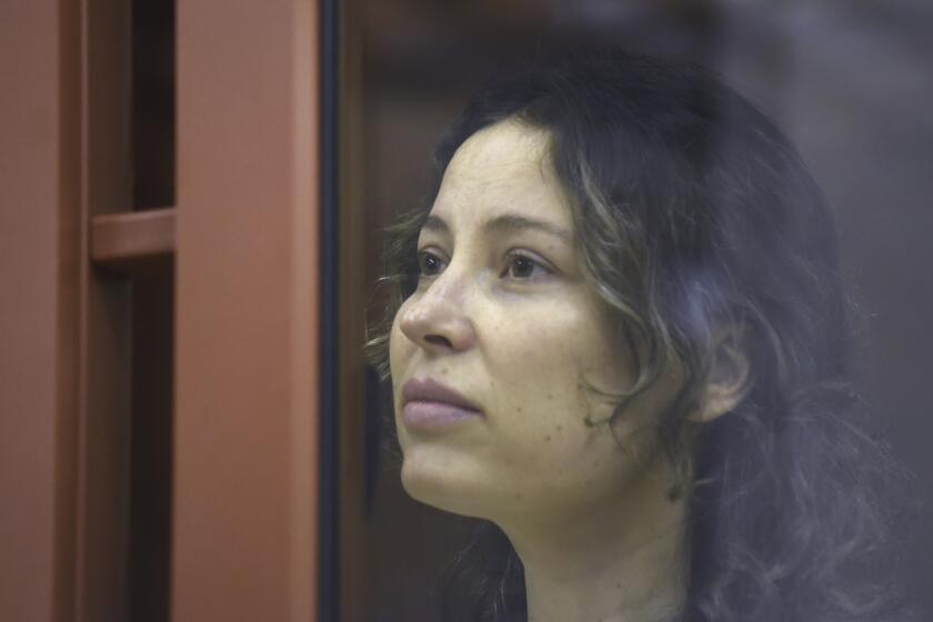 Ksenia Karelina, also known as Khavana sits in a glass cage in a court room in Yekaterinburg, Russia, Thursday, Aug. 15, 2024. A Russian court on Thursday sentenced U.S.-Russian dual national Ksenia Khavana to 12 years in prison on a treason conviction for allegedly raising money for the Ukrainian military. (AP Photo)