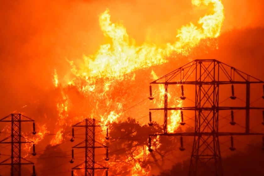 In this Dec. 16, 2017, photo provided by the Santa Barbara County Fire Department, flames burn near power lines in Sycamore Canyon near West Mountain Drive in Montecito, Calif. The huge wildfire that burned hundreds of homes in Santa Barbara and Ventura counties is now the largest in California's recorded history. State fire officials said Friday, Dec. 22, 2017, that the Thomas fire has scorched 273,400 acres, or about 427 square miles of coastal foothills and national forest. That was 154 acres larger than the 2003 Cedar fire in San Diego that killed 15 people. Thousands of firefighters and fleets of aircraft have been battling the blaze since Dec. 4. A firefighter and a woman fleeing the blaze died. (Mike Eliason/Santa Barbara County Fire Department via AP)