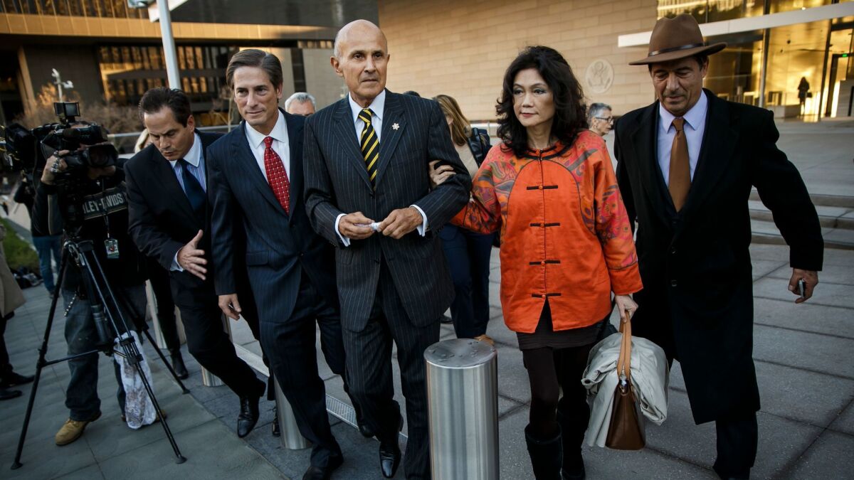 Former Los Angeles County Sheriff Lee Baca, center, escorted by his wife, Carol, right, and his attorney, Nathan Hochman, center left, walks out of a federal courthouse in Los Angeles after Baca's obstruction trial ended in a mistrial.