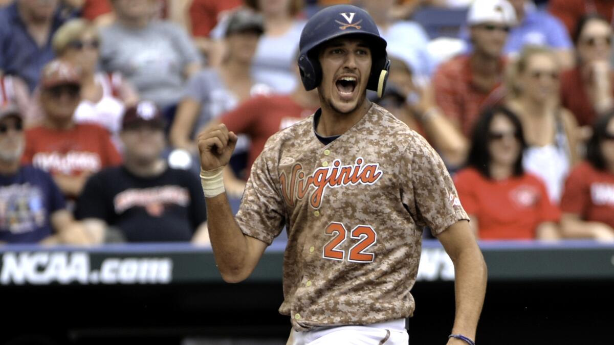 Virginia's Daniel Pinero celebrates after scoring against Arkansas on a double by teammate Kenny Towns in the eighth inning of the College World Series opener on Saturday in Omaha.