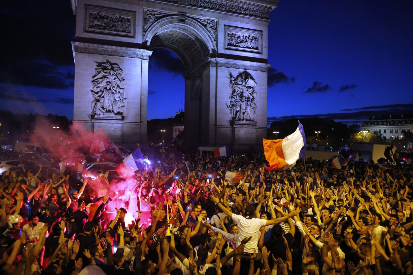 Fans celebrate in front of the Arc de Triomphe after France beat Belgium 1-0 to advance to the finals of the World Cup.