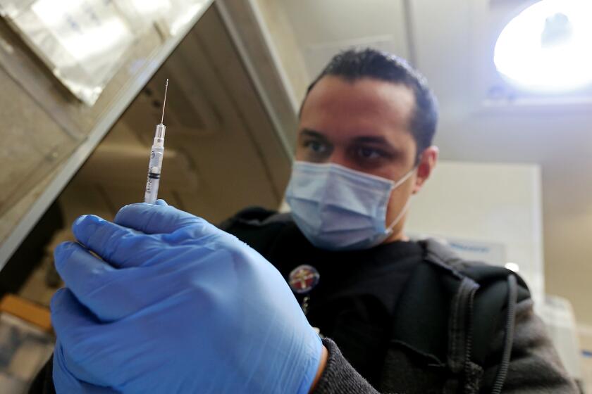 LYNWOOD, CALIF. - MAR. 16, 2022. Nurse Luis Garcia h mixes up childrens dosesof the Pfizer vaccine to be used for kids at Hellen Keller Elementary School in Lynwood on Wednesday, Mar. 16, 2022. (Luis Sinco / Los Angeles Times)