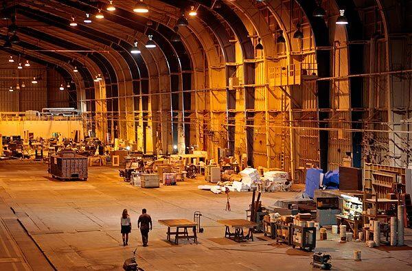 Elizabeth Kubasak, assistant development manager of the Hercules Campus, and Jerry DeSantos of Raleigh Studios walk through the massive hangar where the Spruce Goose was built. The hangar generates about $1.3 million a year in rent from film and TV productions.