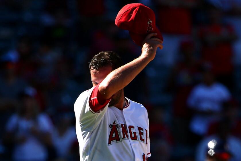 Angels pitcher Huston Street wipes his face in the ninth inning during a game against the Houston Astros at Angel Stadium on Sunday.