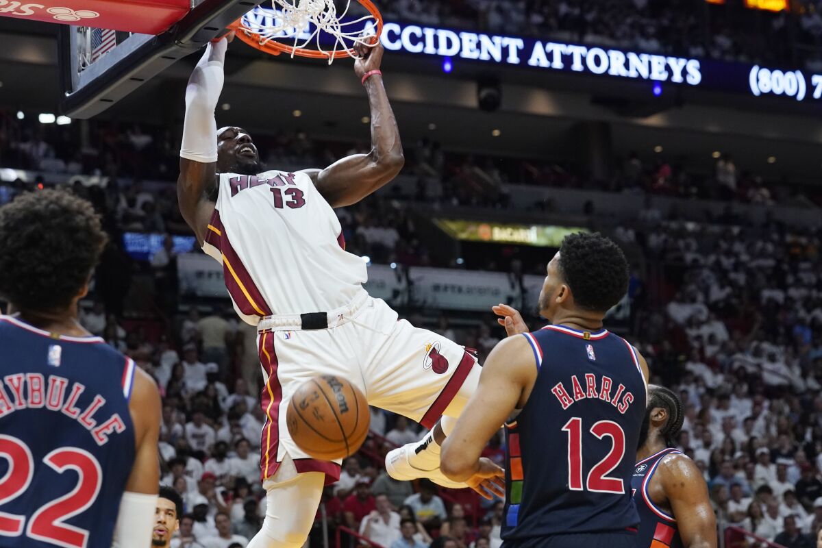 Miami Heat center Bam Adebayo dunks the ball over Philadelphia 76ers forward Tobias Harris.