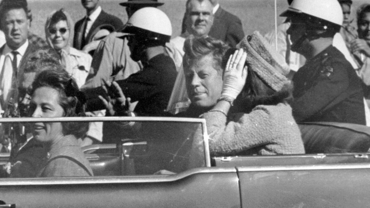 President John F. Kennedy waves from his car in a motorcade in Dallas, Texas on Nov. 22, 1963, the day he was killed.