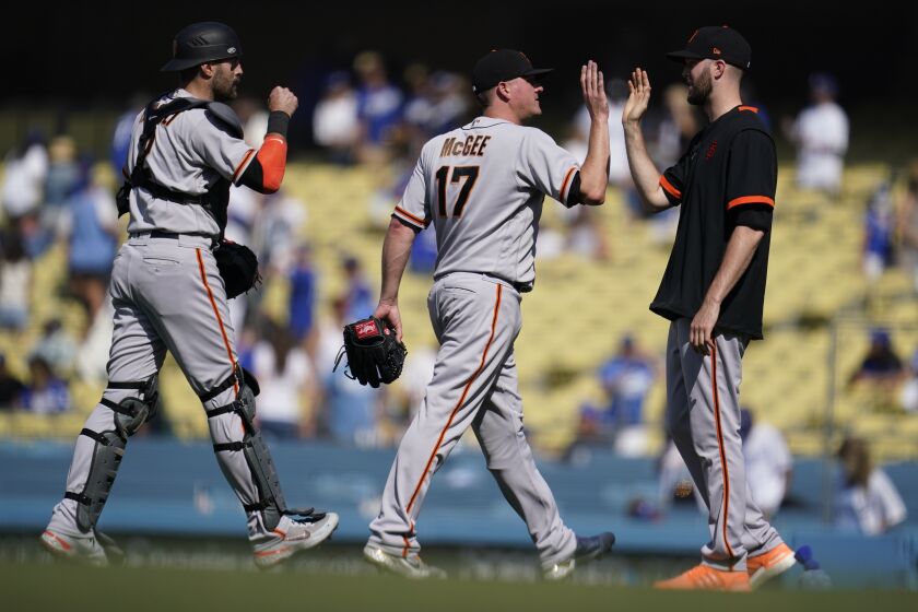 San Francisco Giants catcher Curt Casali, left, and relief pitcher Jake McGee (17) celebrate a 5-4 win.