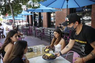 Waiter David Juarez seves customers at Breakfast Company in the Gaslamp Quarter in downtown San Diego on Thursday, July 16 2020.(Photo by Sandy Huffaker for The San Diego Union-Tribune)