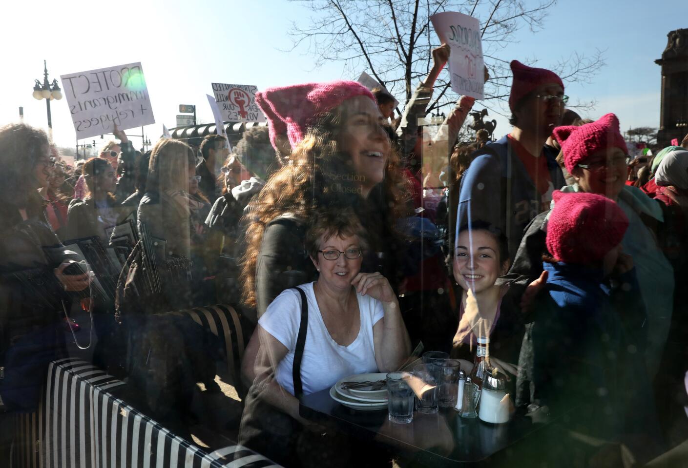 Diners in a cafe along Michigan Avenue look out at a sea of marchers reflected in the windows during the Women's March in Chicago on Jan. 21, 2017.
