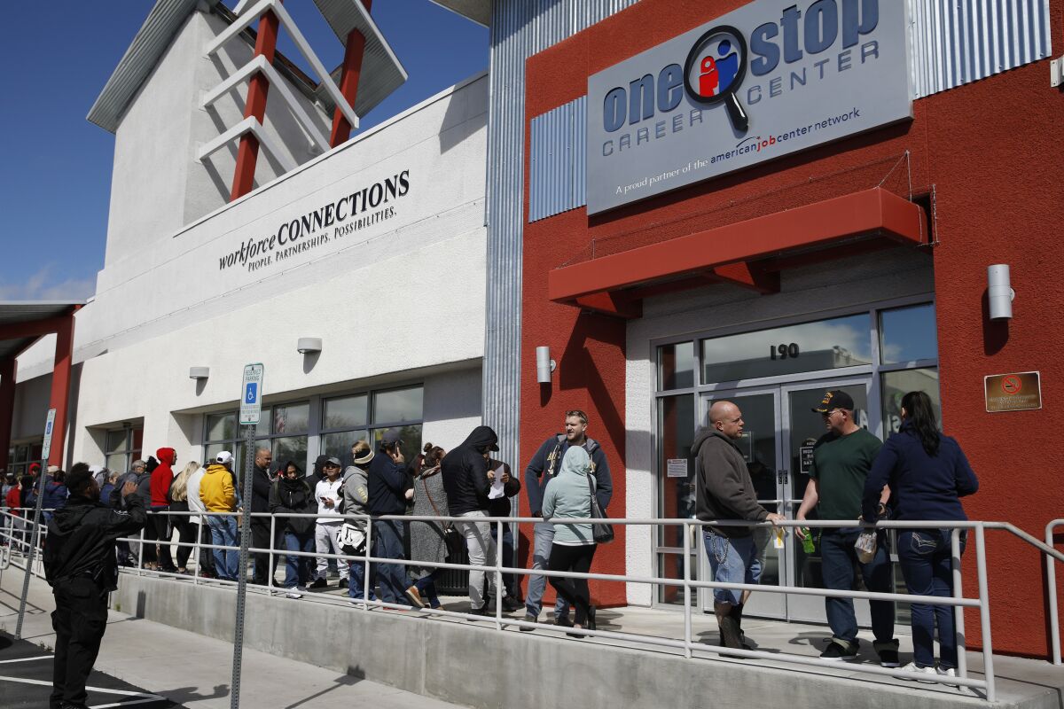 People wait in line for help with unemployment benefits at the One-Stop Career Center in Las Vegas