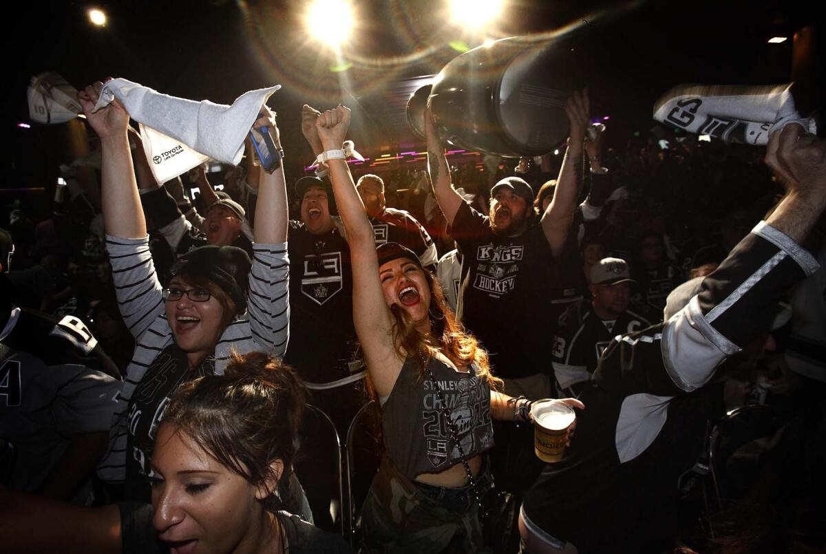 Kings fans including Victoria Ocampo, center, watch the Kings battle the Rangers in the Stanley Cup at the Nokia Theater.