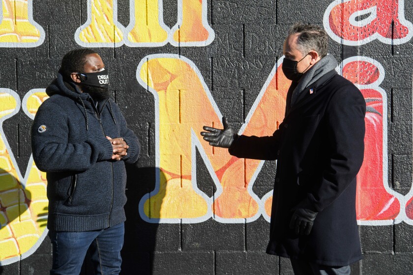 FILE - Second gentleman Doug Emhoff, the spouse of Vice President Kamala Harris, right, speaks with Christopher Bradshaw, executive director of Dreaming out Loud, a nonprofit organization focused on food security and economic opportunity, during a visit to Kelly Miller Middle School in Washington, on Jan. 28, 2021. (Nicholas Kamm/Pool via AP, File)