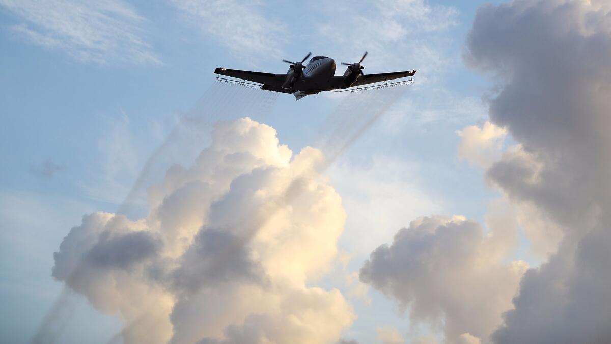 A plane sprays insecticide over Miami's Wynwood district on Aug. 6 to help reduce the population of Zika-spreading mosquitoes.