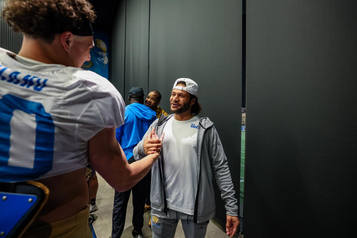 Stacey Ford, UCLA football's director of player personnel, shakes hands with a player.
