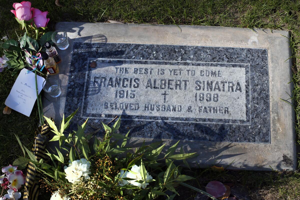 The gravestone of Frank Sinatra is decorated with flowers, liquor bottles and shot glasses at Desert Memorial Park in Cathedral City.