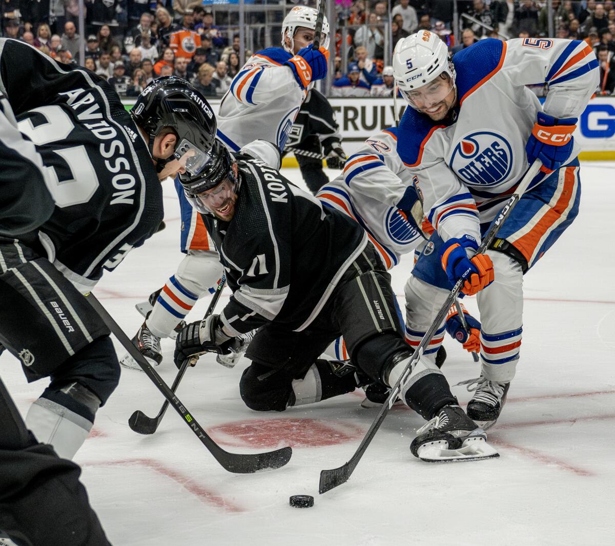 Kings forwards Anze Kopitar and Viktor Arvidsson try to take the puck away from Edmonton Oilers defenseman Cody Ceci.