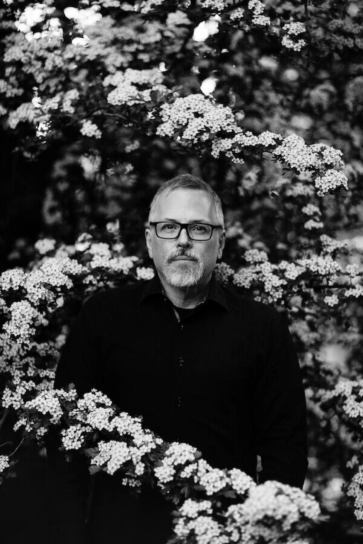 Portrait of a man standing among flowers