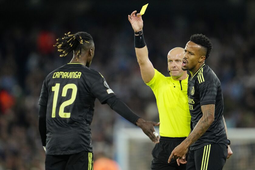 ARCHIVO - El árbitro polaco Szymon Marciniak muestra la tarjeta amarilla a Eduardo Camavinga del Real Madrid, durante el partido de vuelta de la semifinal de la Liga de Capeones ante el Manchester City, el miércoles 17 de mayo de 2023 (AP Foto/Jon Super)