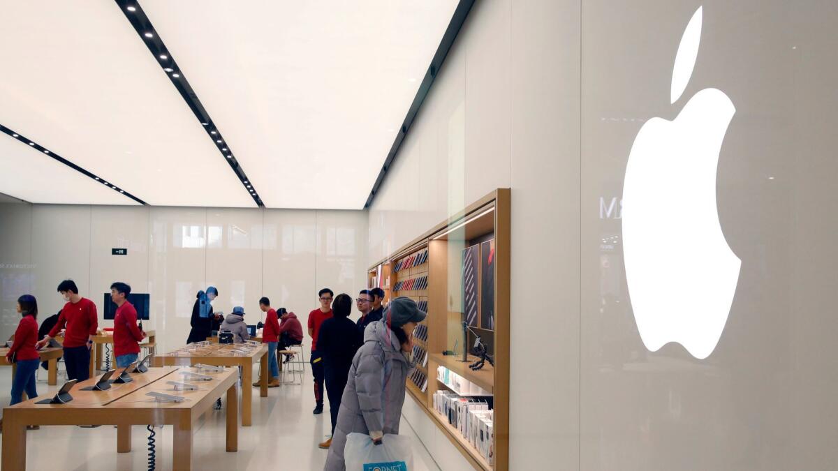 Chinese consumers look at Apple products on display in an Apple Store in Beijing on Jan. 4.